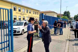 Trescore Balneario: aggressione a scuola, Carabinieri sul posto con ufficiale che parla con una donna nervosa.
